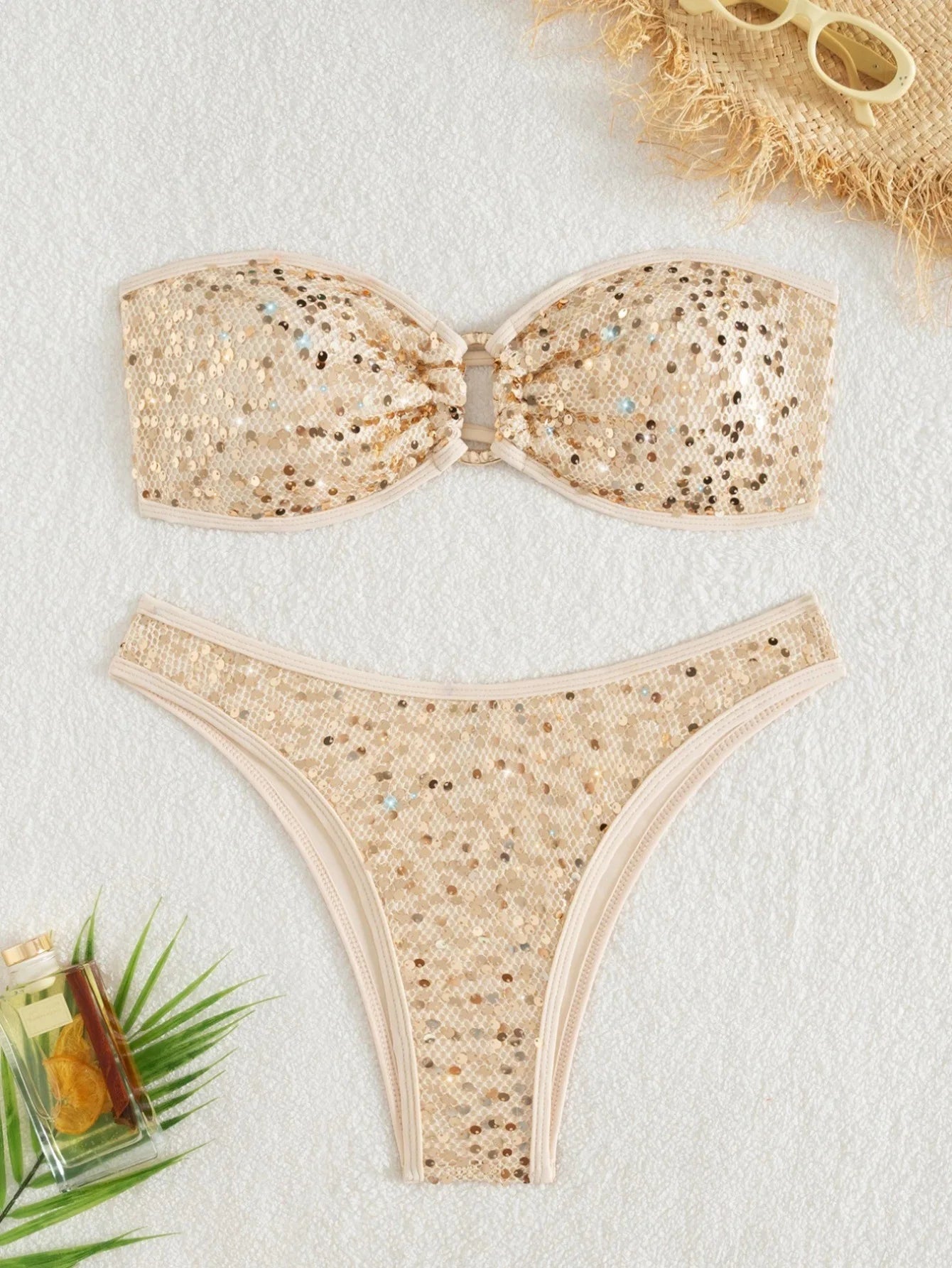 Beige bikini set with sequin details on a light background