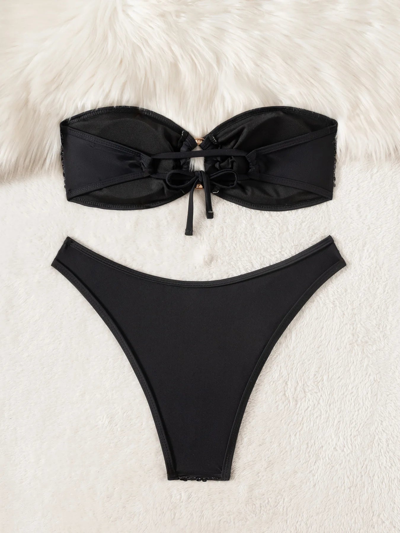 Black bikini set on a white fur background